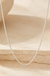 0.6mm Box Chain 10K White Gold on cream stone background