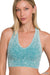 Woman wearing a teal sports bra against a white background