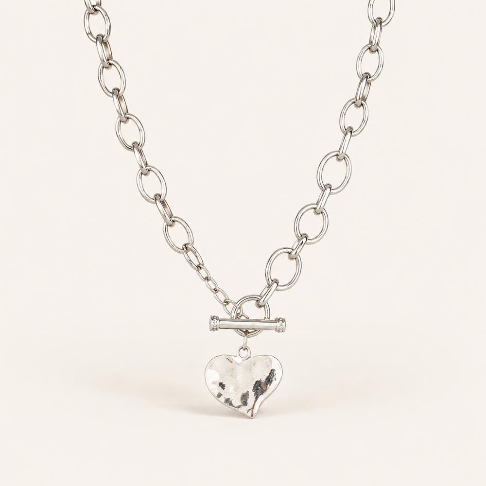 Hammered heart necklaces on warm cream background