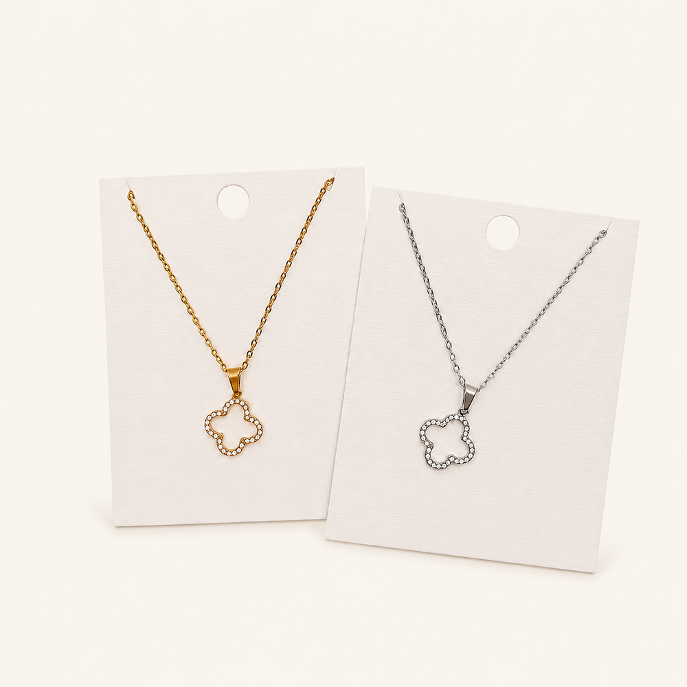 Clover necklace in gold and silver on warm cream background