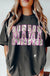 Person wearing a black t-shirt with 'MAMA' printed in pink and camouflage pattern on a light background
