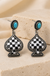 Checker Spade Dangle Earrings on cream stone display