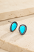 Drop Stone Stud Earrings on cream stone background