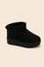 Black ultra mini platform boot on warm cream catalog background