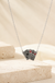 Four Of Aces Necklace on cream stone display