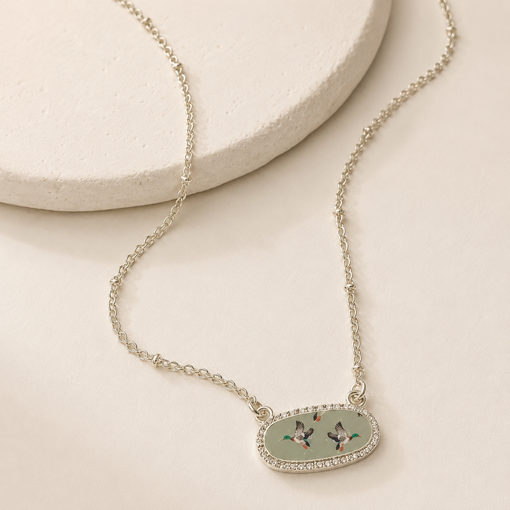 Green Duck Necklace on a warm cream stone display