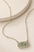 Green Duck Necklace on a warm cream stone display