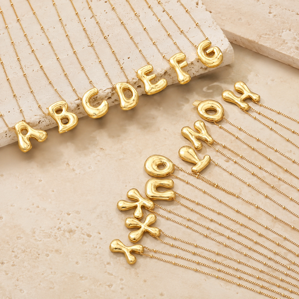 Stainless Steel Balloon Initial Necklace on cream stone display