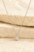 Sterling Silver Curly Heart Necklace on cream stone background