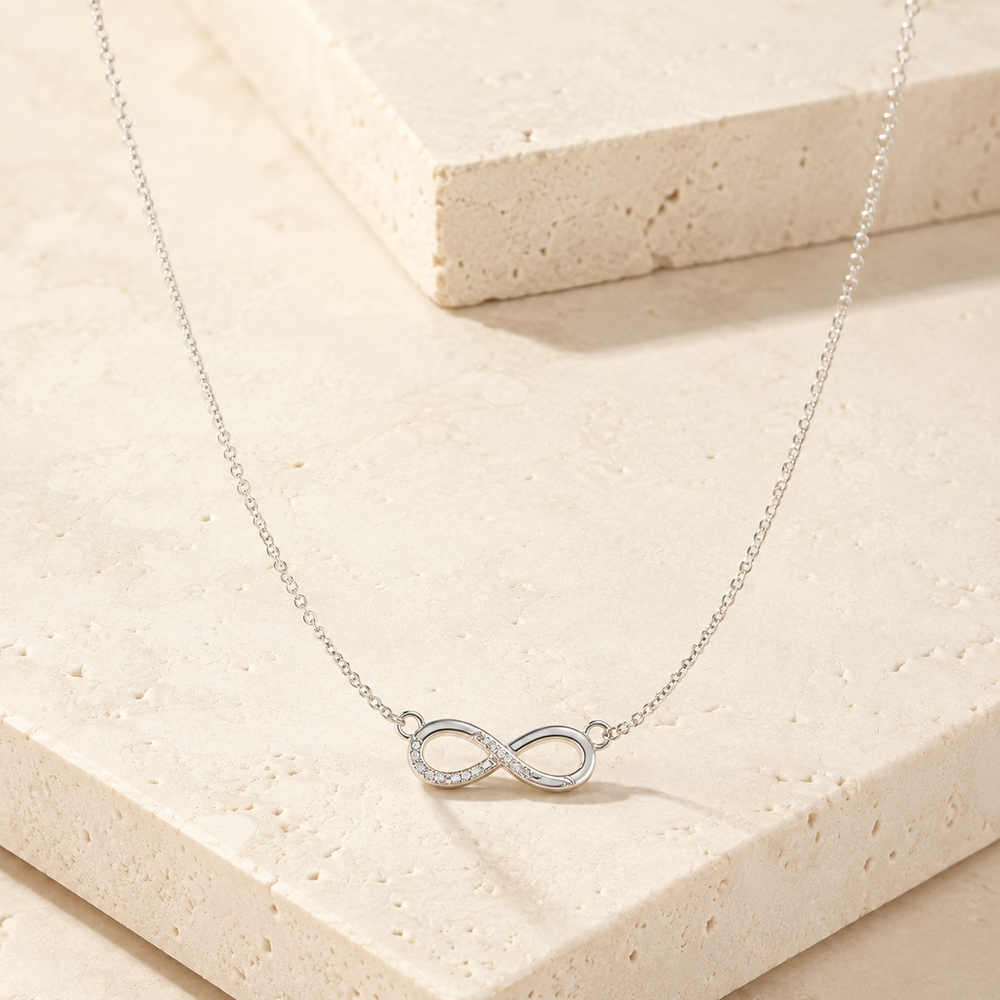 Sterling Silver Infinity Sign Necklace on cream stone background