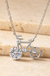 Sterling Silver Moissanite Bicycle Pendant Necklace on cream stone background