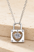 Sterling Silver Moissanite Heart Lock Charm Necklace on cream stone background