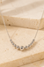 Sterling Silver Tier Bead Necklace on cream stone background