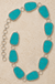 Textured trapezoid gemstone chain belt on cream stone