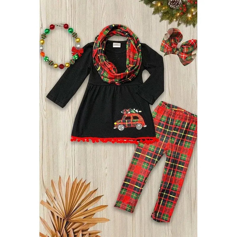 Túnica negra con aplique de árbol sobre un auto, bufanda estampada multicolor y leggings a juego.